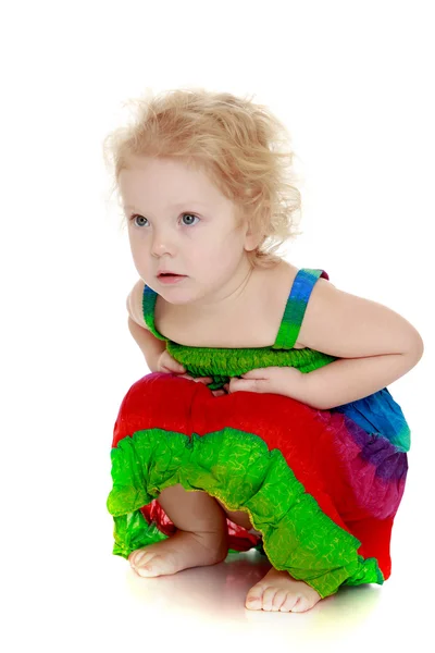 Pretty little blond girl squatted — Stock Photo, Image