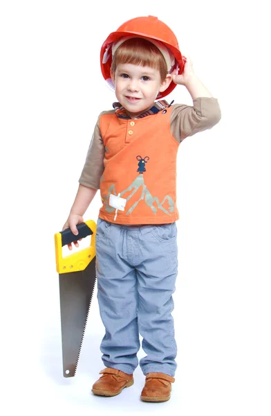 Niño divertido en el casco de construcción sosteniendo una sierra de hackear — Foto de Stock