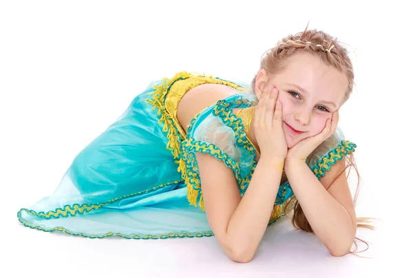 Elegantes kleines Mädchen im orientalischen Kostüm auf dem Boden liegend — Stockfoto