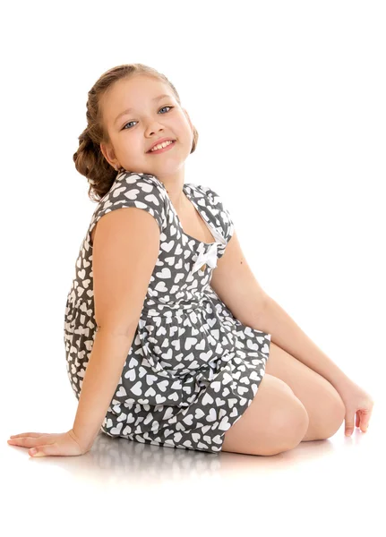 Veselá dívka v letních šatech sedí na podlaze — Stock fotografie