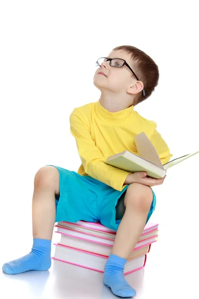 Petit garçon avec des lunettes lisant un livre — Photo