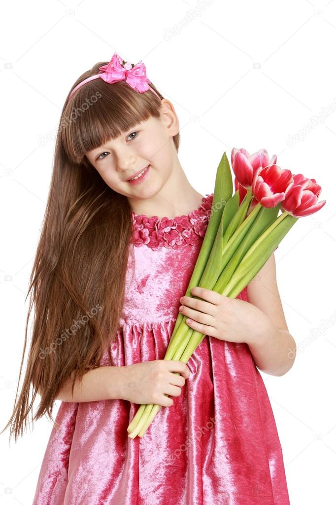 Fashionable little girl with long hair holding a bouquet of flow