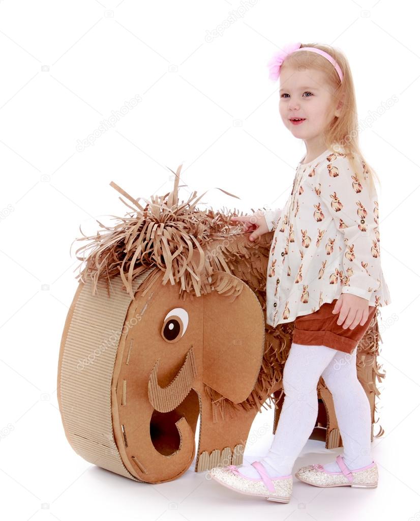little girl next to an elephant made of corrugated cardboard