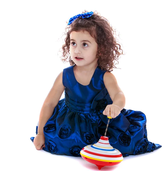 Cute little girl sitting on the floor and playing dreidel — Stock Photo, Image