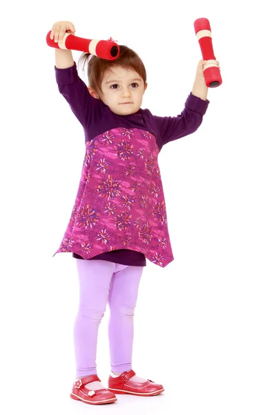 Pretty little girl raised her head above the dumbbell — Stock Photo, Image