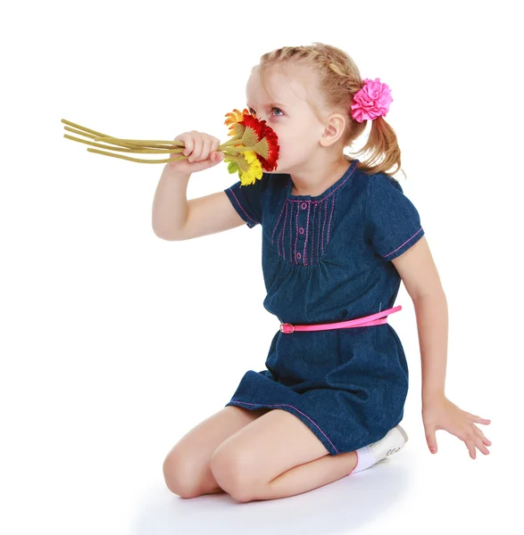 Entzückendes kleines Mädchen, das einen Blumenstrauß riecht — Stockfoto