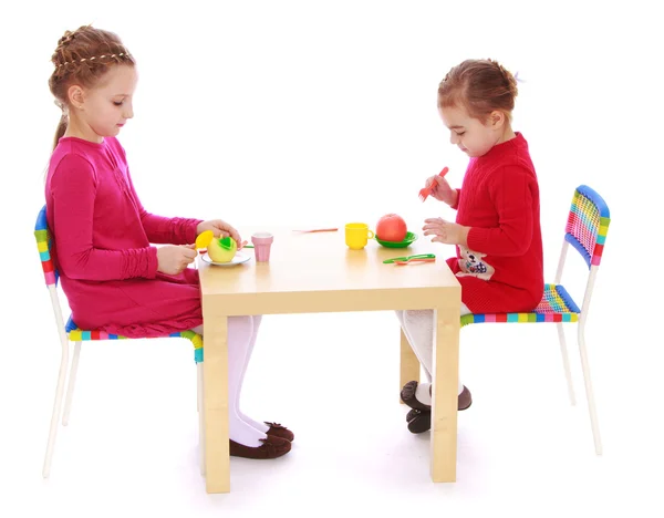 Iki küçük kız masada oynarken — Stok fotoğraf
