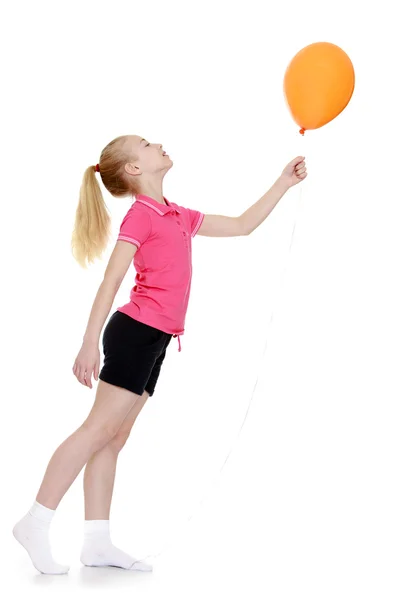 Beautiful caucasian girl holding at arms length balloons, stand — Stock Photo, Image