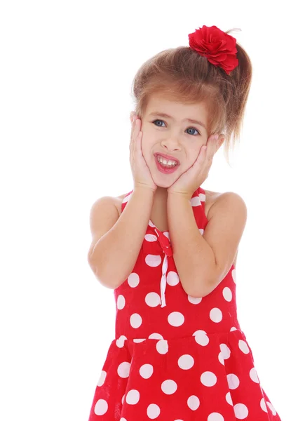 Niña en un vestido rojo con lunares blancos en la mano — Foto de Stock