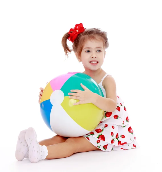 Menina no vestido de verão sentado no chão com um balcão inflável — Fotografia de Stock