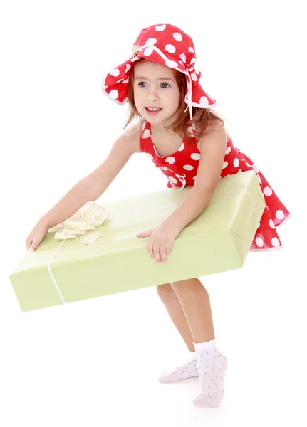 Ragazza in un abito estivo rosso e cappello in possesso di una grande scatola regalo — Foto Stock