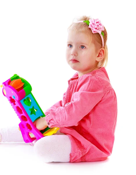 Girl in pink dress with a toy — Stock Photo, Image