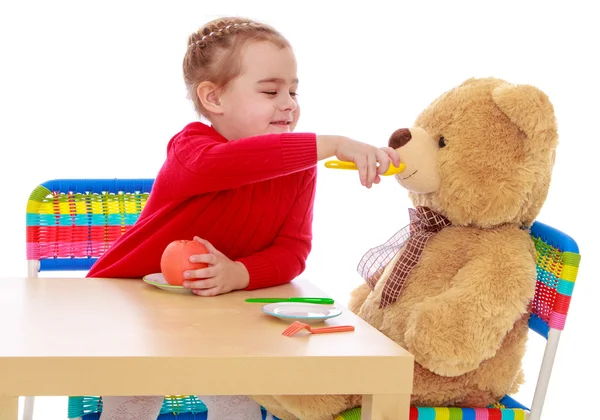 Meisje voeding een teddybeer — Stockfoto