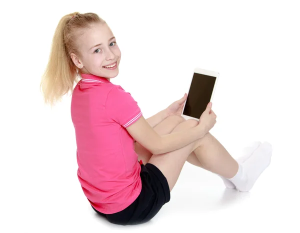 Chica sentada con una tableta PC o libro electrónico —  Fotos de Stock