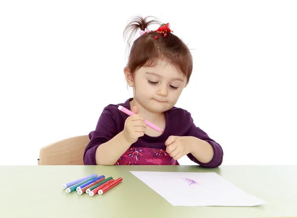 Het kleine meisje trekt markeringen aan de tafel — Stockfoto