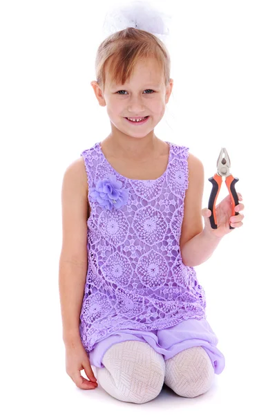 The girl in purple dress holding pliers — Stock Photo, Image