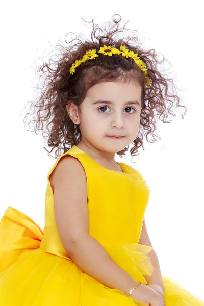 Retrato de uma menina de cabelos encaracolados com flores amarelas — Fotografia de Stock