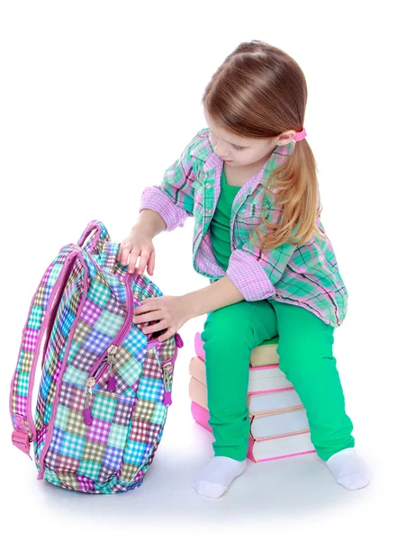 The girl opens a school backpack — Stock Photo, Image