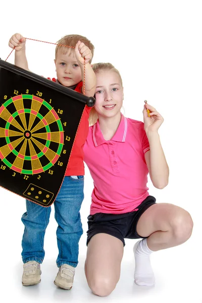 Brother and sister playing a game of darts. — Stock Photo, Image