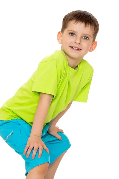 Uśmiechnięty chłopiec trzymając się za ręce na kolanach. — Zdjęcie stockowe