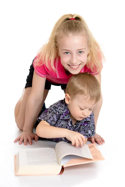 Kız ve erkek kardeşim katta oturan bir kitap okuma — Stok fotoğraf