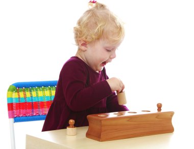 Çok güzel beyaz Montessori malzeme ile oynarken küçük kız 