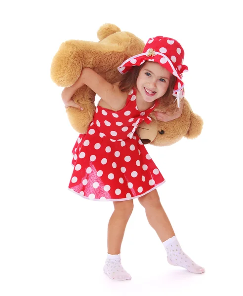 Lächelndes kleines Mädchen beim Spielen mit einem Teddybär — Stockfoto