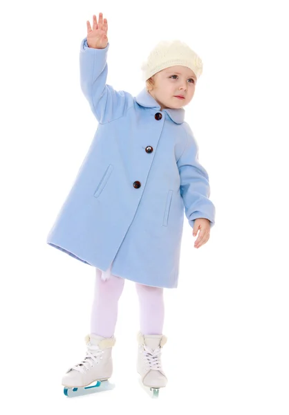 Adorable niña patinaje sobre hielo en un abrigo azul y sombrero —  Fotos de Stock