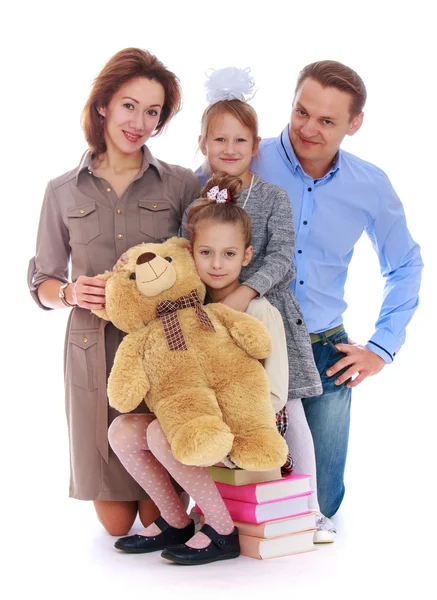 Beautiful family mom dad and two daughter hugging Teddy bear — Stock Photo, Image