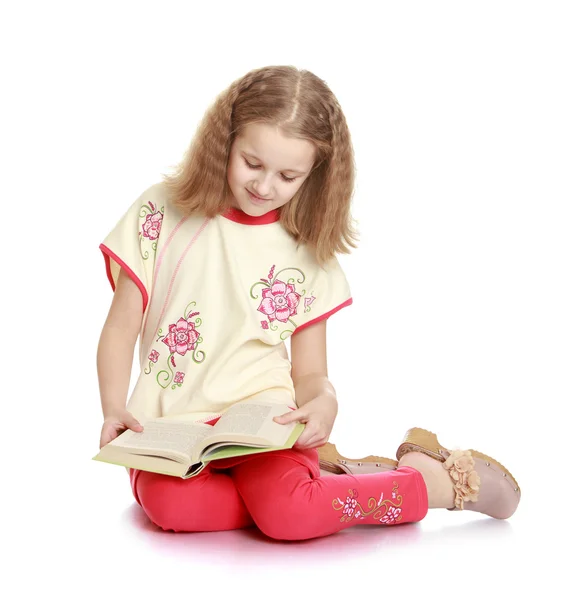 Okouzlující školačka čtení dobré knihy, sedí na podlaze — Stock fotografie