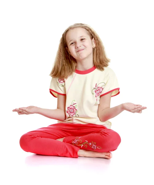 Bella bionda bambina seduta sul pavimento meditando in t — Foto Stock