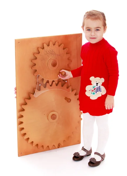 Mädchen dreht per Hand Zahnräder in Montessori — Stockfoto