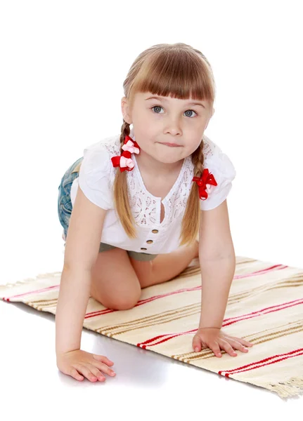 Entzückendes kleines Mädchen mit langen Zöpfen auf dem Kopf spielt — Stockfoto