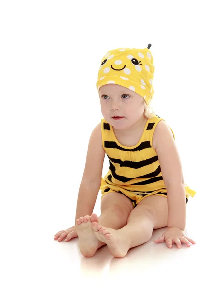 Velmi malá holčička v kostýmu pruhovaných včel sedí na podlaze b — Stock fotografie
