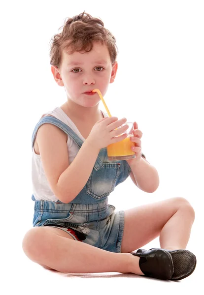 Pequeño niño en pantalones cortos de mezclilla bebiendo —  Fotos de Stock