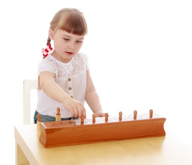 Oturan bir Montessori anaokulu, akıllı küçük kız ta