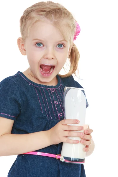 Забавная маленькая девочка держит стакан молока, крупным планом — стоковое фото