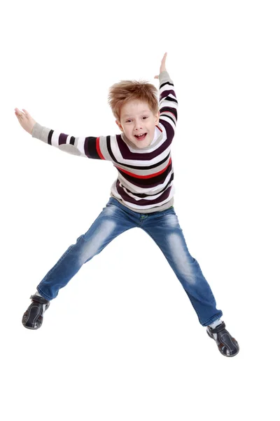 Funny little boy in striped t-shirt jumps with her legs out to t — Stock Photo, Image