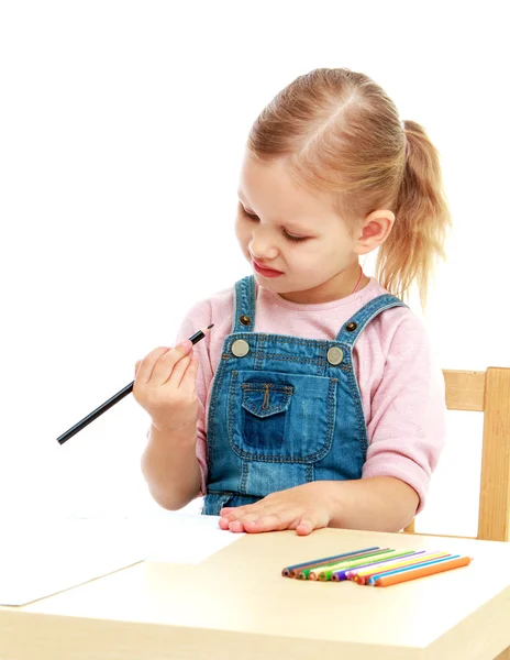 Little girl in kindergarten is considering the pencil sitting on — Stock Photo, Image