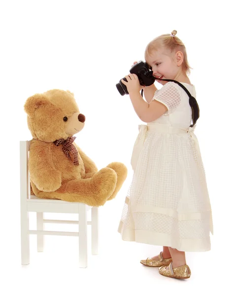 Niña tomando fotos de un osito de peluche — Foto de Stock