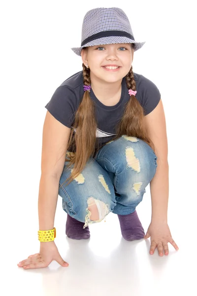 Beautiful teenage girl in worn-through jeans and a hat — Stock Photo, Image