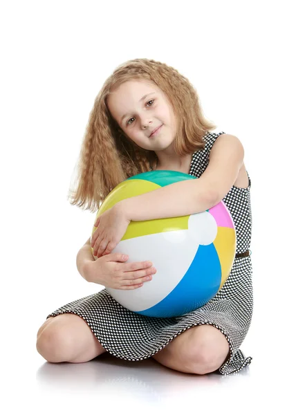 Ragazza seduta sul pavimento abbracciando una grande palla da spiaggia — Foto Stock