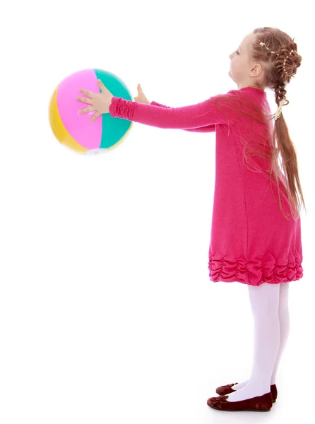 The little girl turned sideways to the camera and holding a ball — Stock Photo, Image