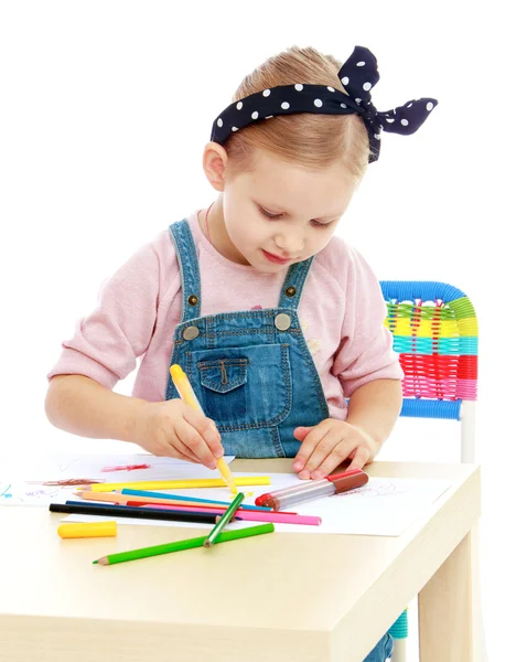 Little girl in denim overalls and a bandage on his head draws wi — Stock Photo, Image