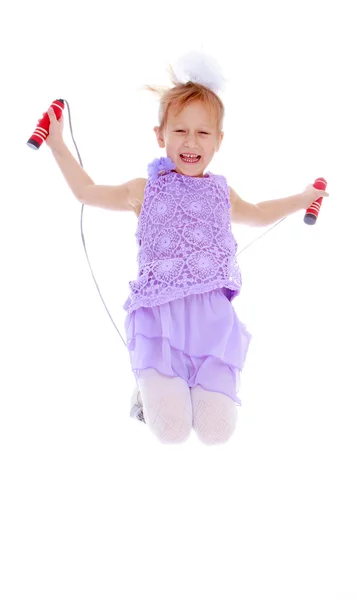 La bambina allegra che salta saltando corda isolata su bianco — Foto Stock