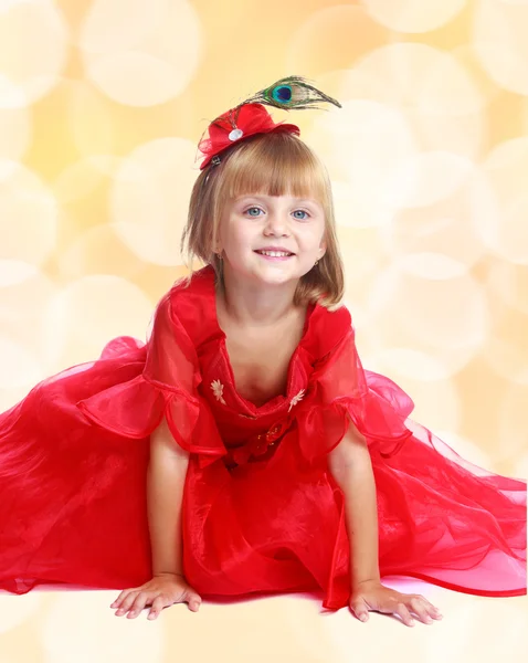 Fashionable blonde girl in a bright red dress sitting on the flo — Stock Photo, Image