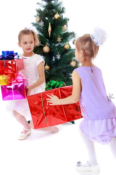 Chicas hermanas alrededor del árbol de Navidad alboroto teniendo en cuenta las cajas w — Foto de Stock