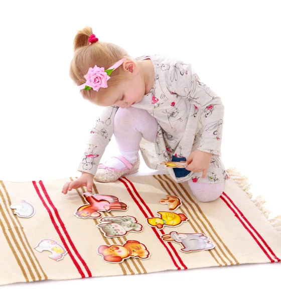 Дівчина грає в карти, сидячи на килимку — стокове фото