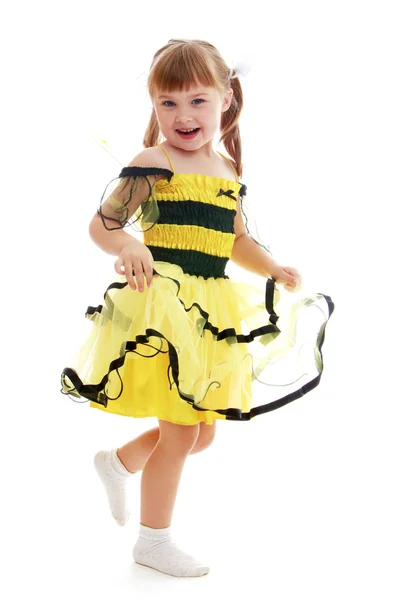 Menina alegre em exuberante vestido listrado preto e amarelo — Fotografia de Stock