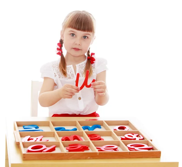 Liten flicka kör med bokstäverna i montessori förskola — Stockfoto